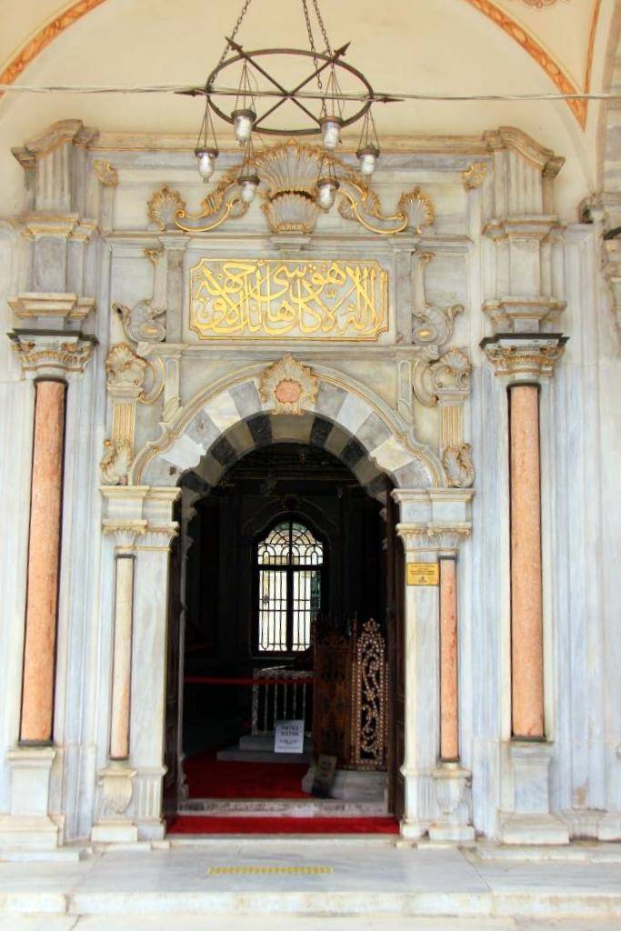 yuvarlak kemerli türbe kapısının kilit taşında stilize edilmiş bir istiridye kabuğu motifi bulunmaktadır.